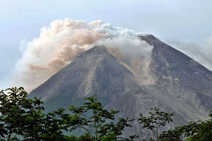 10月27日，搜救人员在印度尼西亚默拉皮火山附近搬运遇难者。