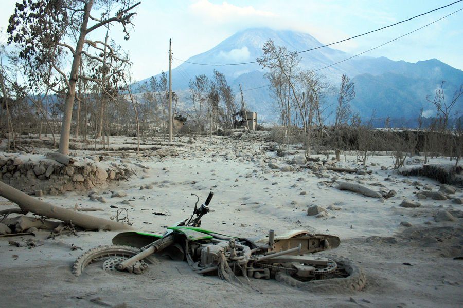 当地时间10月26日，印尼日惹默拉皮火山附近，街道上的汽车已经蒙上了一层火山灰。